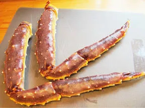 Rå kongekrabbe. Klipp forsiktig opp skallet og ta ut kjøttet. Legg på et stykke kjøkkenpapir.