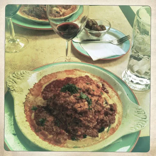 Lasagna på en glovarm tallerken.