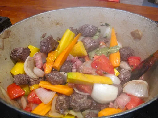 Så tilsetter du gulrot, appelsinskall og tomat samt rødvinen fra marinaden. Kok inn i et par minutter. 