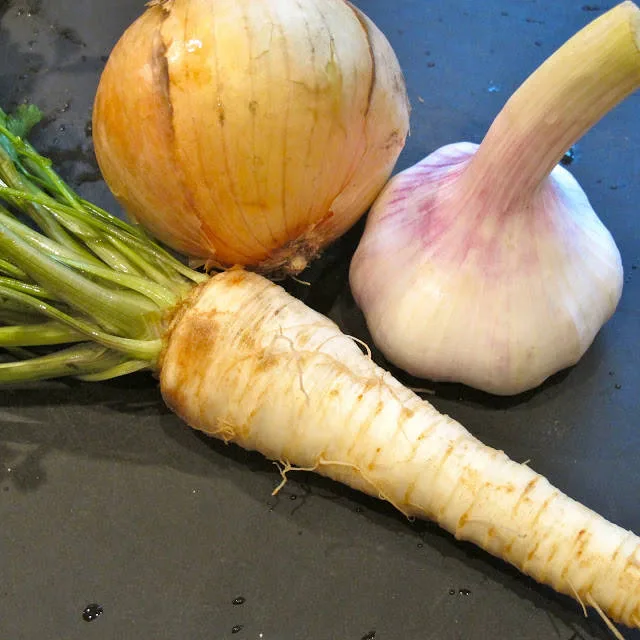 Persillerot med bladpersillebusk, fersk hvitløk og store, saftige løk.