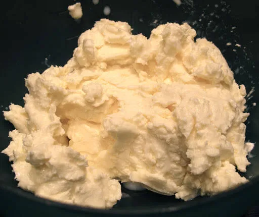 Ferdig smør klar til salting. Smørklatten er tatt ut av bollen og presset fri for overflødig væske. Bruk et rent klede eller tøystykke til denne prosessen.