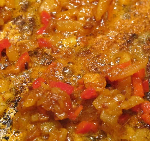 I en gryte mykner du løken i smør på lav varme i 10 minutter. Tilsett chili og krydder og rør forsiktig. Når alt er blandet tilsetter du kyllingkraft.