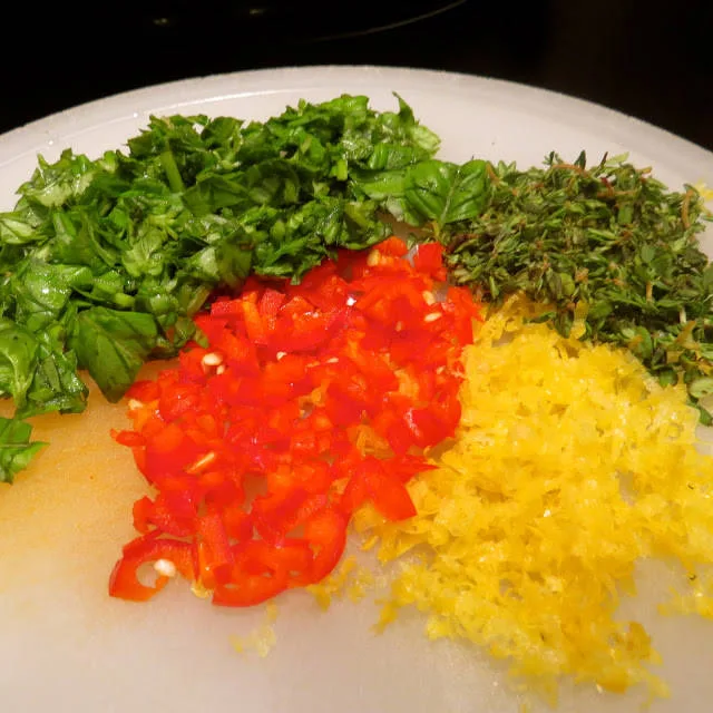 Hakk opp chili, timian og basilikum. Riv sitronskall etter ønske.