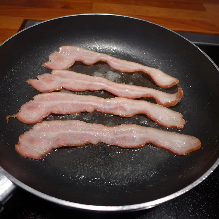 Vannet er fordampet, baconet begynner å steke.