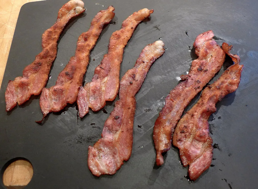 Bacon stekt på ny måte til venstre. Vanlig stekt bacon til høyre. 