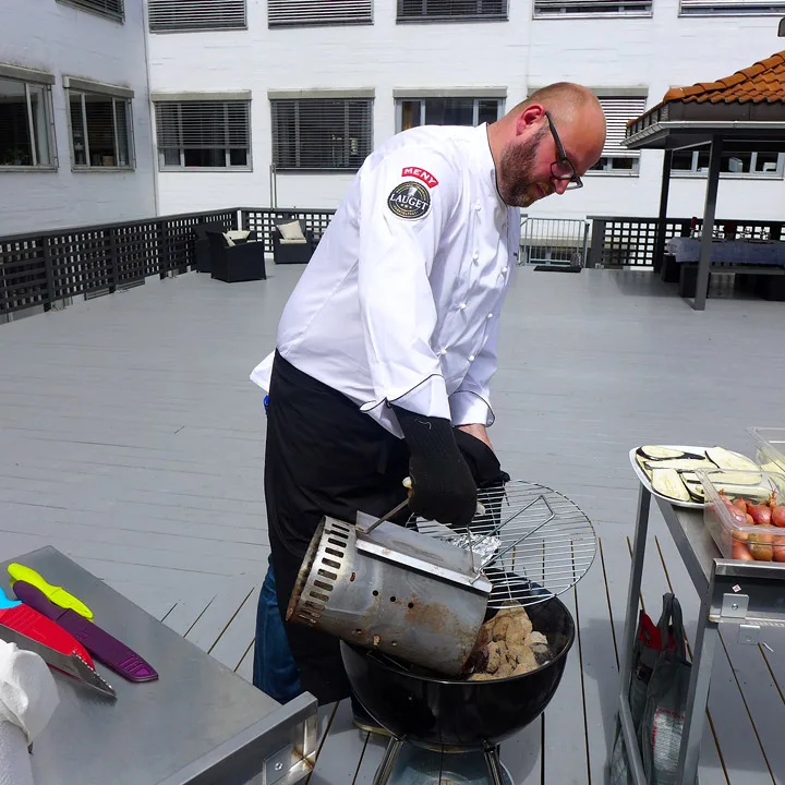 Espen heller grillbrikettene i grillen når de er grå. Han bruker et opptenningsrør for å få jevn varme på brikettene.