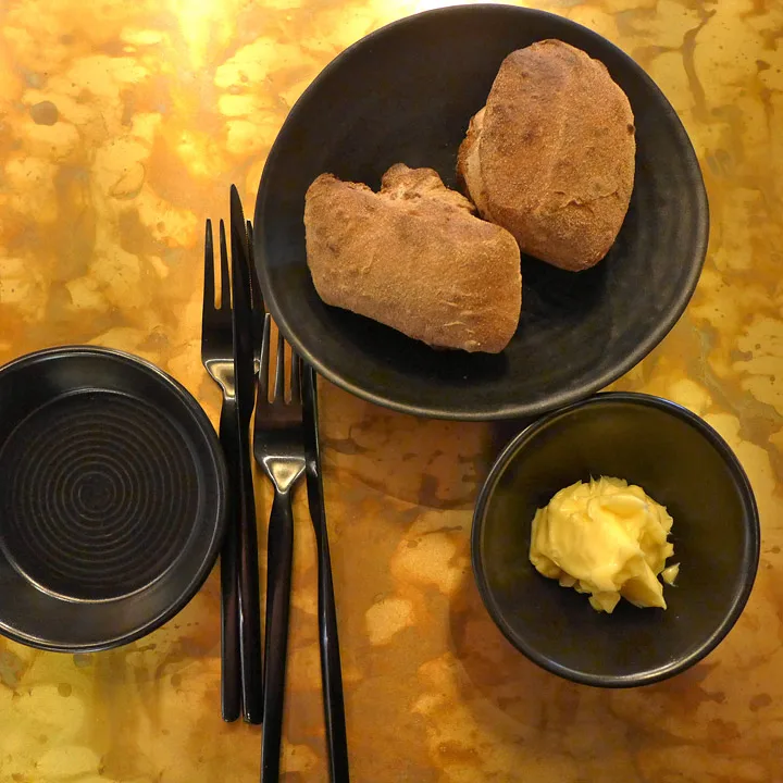 Salt smør, lunt brød og stilig sort bestikk.
