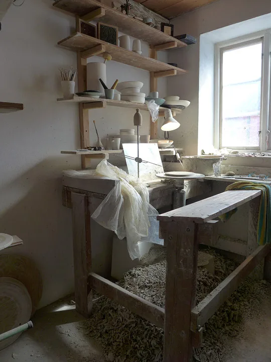 Arbeidsbenken og dreieskiven. All leiren som ligger på bakken, brukes på nytt.