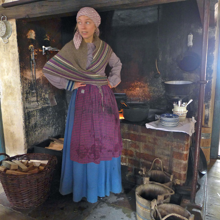 Ekte skuespillerer står stasjonert rundt omkring i Den gamle by og spiller tidsriktige roller. Dette er fra kjøkkenet til Købmanden i byen der tjenestepiken lager måltider til sin herre. Gjestene som kommer til Den Gamle By i Århus er velkommen til å gå inn i de forskjellige husene og smake på det som lages av historiske retter.