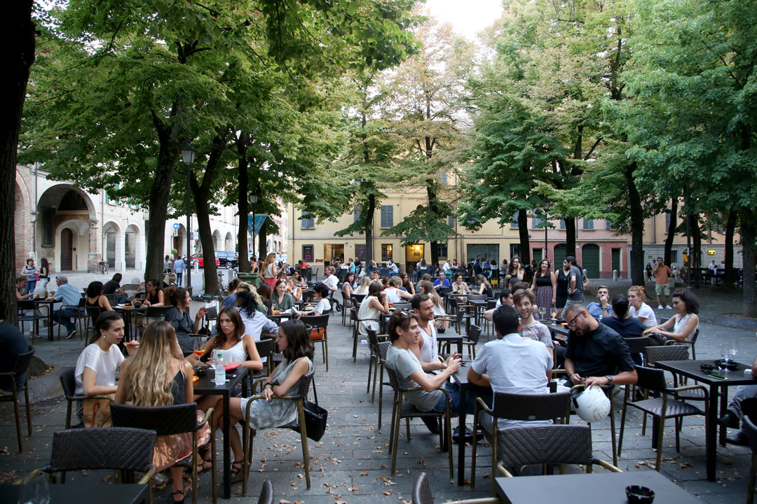 Piazza Fontanesi midt i aperitivo-timen. Her kan du sette deg på et utested og bestille en drink og så gå å forsyne deg med litt mat, helt gratis. Dette gjør italierne før de da går ut å spiser.